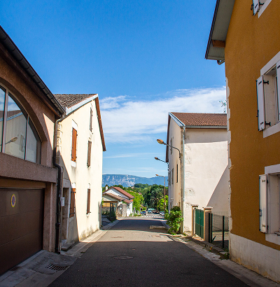 Rue de village avec maisons traditionnelles et vue sur les montagnes