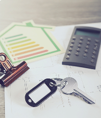 Clés, calculatrice et étiquette énergétique sur un plan de construction