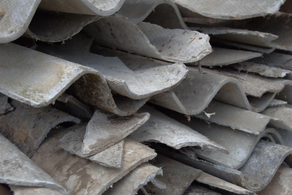 Pile de plaques ondulées en fibrociment, toiture ancienne à risque amiante