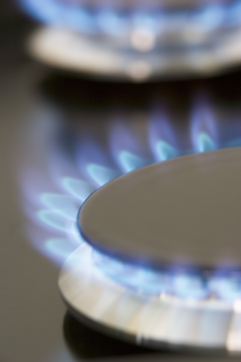 Flammes bleues d'un brûleur de gaz sur une plaque de cuisson